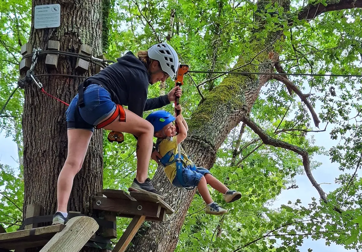 Famille pratiquant l'accrobranche en Dordogne sur les parcours d'AirParc