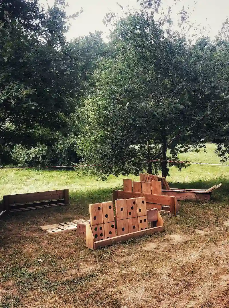 Espace jeux en bois traditionnels et géants à l'ombre des arbres d'AirParc.