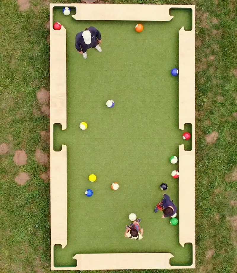 Partie de Snookball en plein air : un mélange ludique entre football et billard géant.